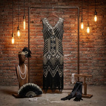 Robe charleston années 1920 noire à perles argentées et blanches avec motifs géométriques et franges fines