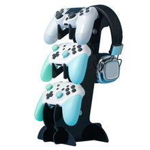 Support à trois niveaux en acrylique noir tenant trois manettes blanches et teal avec casque gaming argenté