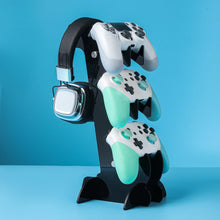 Support à trois niveaux en acrylique noir pour casque gaming et manettes blanches et vert menthe en présentation organisée