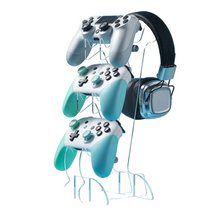 Support à trois niveaux en acrylique clair tenant trois manettes et un casque gaming noir