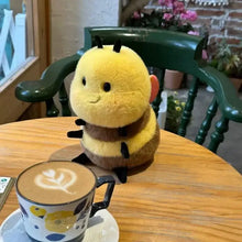 Peluche abeille kawaii 20 cm jaune et marron avec antennes noires posée sur une table en bois