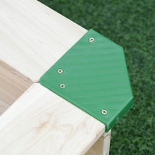 Green plastic corner protector with textured surface secured by screws on light wooden bac à sable bois avec couvercle