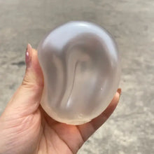 Balle anti-stress squishy nacrée translucide légèrement irisée tenue en main pour malaxer et déstresser