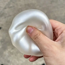 Balle anti-stress squishy nacrée translucide blanche avec surface lisse et légèrement brillante à malaxer