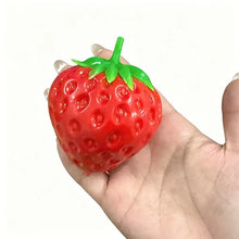 Balle sensorielle fraise rouge brillante en plastique avec texture croquante et dessus feuillu vert pour presser