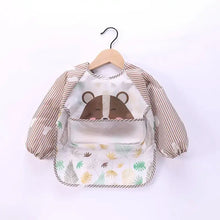 Bavoir tablier à manches longues pour enfant avec visage dours marron et motif feuillage vert et jaune doux