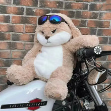 Peluche lapin blanc tan et blanc avec lunettes de soleil bleues reflétantes posé sur une moto avec air fâché
