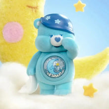 Un nounours câlin bleu doux avec un bonnet de nuit étoilé et un motif lune et étoiles sur le ventre dans une boîte mystère figurines nounours pop mart