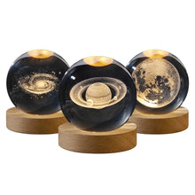 Lampe boule en verre gravé 3d avec socle bois illuminée de trois sphères noires à motifs célestes dorés