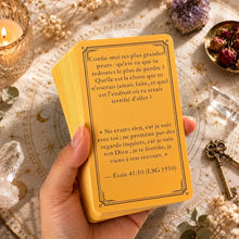 Une main tient un paquet de cartes oracle jaune avec texte français noir idéal pour idée cadeau ou magasins de jouets