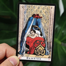 Carte vintage de tarot oracle italien avec enfant endormi en robe rouge sous un dais bleu orné doré et noir