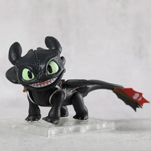 Figurine krokmou chibi noire 7 cm avec yeux verts lumineux et harnais métallique dans sa boîte