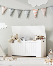 Coffre de rangement banc enfant blanc en bois avec latte verticale et couvercle à charnière contenant peluches et coussin rayé