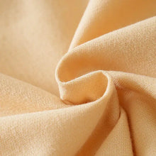 Combinaison bébé garçon en tissu tricoté pêche pale doux avec texture subtile et léger brillant
