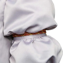 Une ceinture torsadée orange et or en corde décorative ceint le taille d’un vêtement gris satin pour costume cosplay clown penny