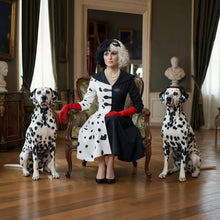 Femme assise en robe à pois noir et blanc avec col noir et boutons cœur costume cosplay cruella deville