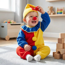 Bébé souriant en costume de clown coloré rouge jaune bleu avec nez pompon et chapeau, enfant pourra s’amuser