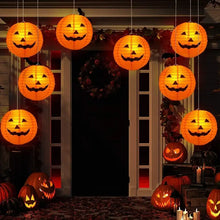 Lot de cinq lanternes citrouille halloween en papier orange avec visages jack-o-lantern suspendues au-dessus d’une porte