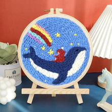 Kit de broderie punch needle avec motif baleine bleue texturée et ours rouge sur fond étoilé et arc en ciel