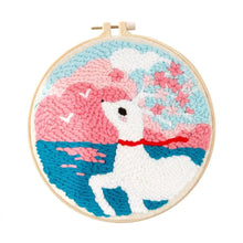 Kit de broderie punch needle avec motif cerf blanc à col rouge sur fond de collines roses et bleues avec fleurs