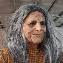 Masque réaliste de grand-mère à cheveux gris avec visage vieilli et rides détaillées porté sur chemise à carreaux orange et marron