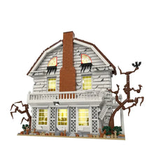 Jeu de construction maison du diable avec maison inquiétante en briques blanches et marron et fenêtres jaunes lumineuses