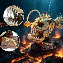 Modèle de construction poisson abyssal beige et noir avec lanterne orange sur socle volcanique sous-marin
