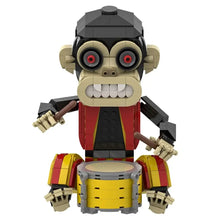 Figurine lego singe dhorreur beige et noir aux yeux rouges vêtue rouge et jaune derrière un tambour jaune jeu de construction singe dhorreur 487 pièces
