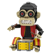 Lego construction singe d’horreur beige et noir avec yeux rouges et tenue rouge jaune jouant de la batterie jaune gris