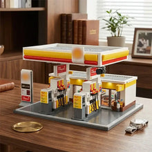 Modèle lego détaillé station d’essence shell avec nombreux éléments jaunes rouges et pompe grise pour construction station