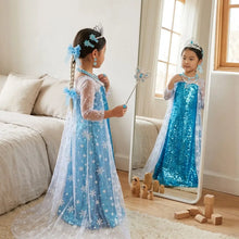 Une jeune fille porte un déguisement princesse elsa diamant bleu pailleté avec surcouche blanche transparente et motifs flocon
