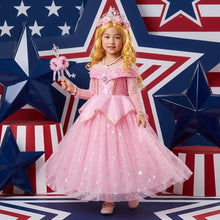 Une jeune fille porte une robe princesse aurora rose avec corsage pailleté et jupe en tulle étoilée argentée avec nombreux accessoires