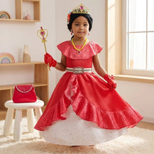 Une jeune fille porte une robe princesse elena rouge et blanche avec nombreux accessoires dorés et une baguette rose