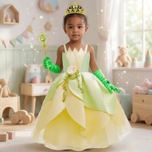 Un enfant porte une robe princesse grenouille verte et jaune à volants avec gants assortis et diadème en bijoux