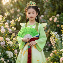 Une jeune fille porte une robe princesse mulan verte et rouge avec bordure dorée et ailes papillon assorties