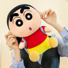Plush toy shin-chan écolier espiègle with round face, red shirt, blue straps, yellow shorts and backpack