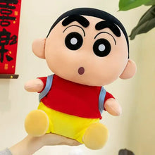 Peluche écolier espiègle shin-chan avec visage rond, yeux noirs, chemise rouge, short jaune et sac à dos bleu