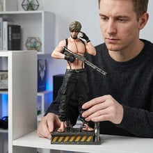 Figurine leon s kennedy resident evil en métal noir et gris montrant un homme musclé en tenue tactique avec fusil sur base détaillée