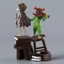 Figurine little nightmares iii montrant deux personnages fantastiques avec capes et outils dont un arc et une clé anglaise
