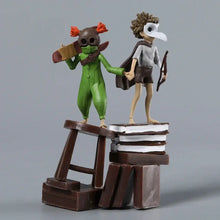Deux figurines stylisées little nightmares iii avec combinaison verte et masque, debout sur tabourets en bois sur livres empilés