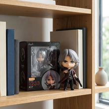 Figurine nendoroid dante devil may cry argentée chibi posée à côté de son emballage dorigine sur étagère en bois