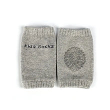 Genouillères souples pour bébé en gris avec patch antidérapant et broderie kids socks aux dimensions annoncées 8 x 11 cm