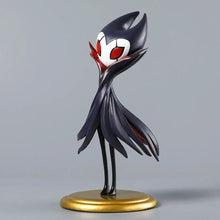 Figurine hollow knight grimm en noir et blanc avec yeux rouges sur socle doré pour collection boîte illustrée