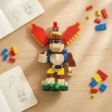 Lego moc banjo kazooie présentant un singe brun, beige et jaune avec des ailes rouges en briques plastique emboîtables