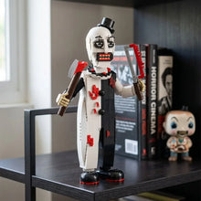 Lego moc clown terrifier en lego avec un clown blanc et noir aux accents rouges tenant deux haches