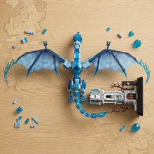 Lego moc dragon de glace translucide bleu avec ailes détaillées et queue segmentée à côté de son château assorti