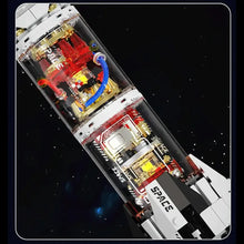 Modèle lego moc fusée décollage transparent avec panneaux blanc noir, composants rouges, tuyaux bleus et accents or