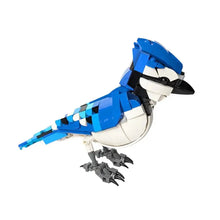 Lego moc oiseaux modèle en lego bleu et blanc avec accents noirs sur bec, yeux et bouts dailes dans animaux volants