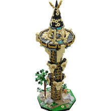 Lego moc zelda tour sheikah présentant une tour beige et noire avec accents dorés sur base verte avec arbres miniatures