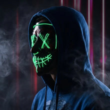 Masque intégral lumineux vert avec dessin yeux en x et bouche cousue porté sur un hoodie bleu foncé pour halloween